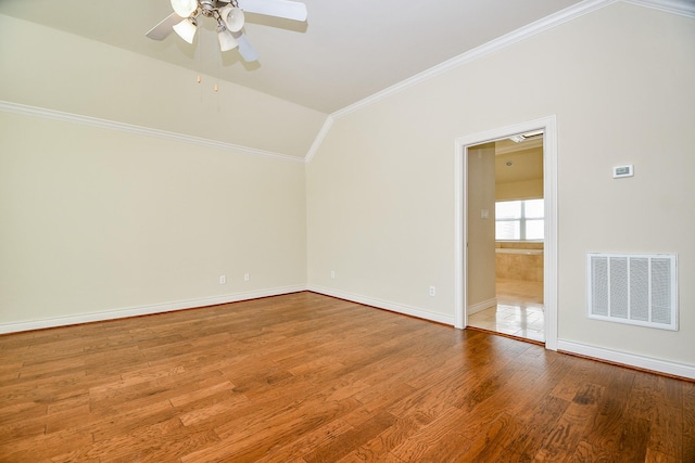 empty room with visible vents, ornamental molding, a ceiling fan, wood finished floors, and baseboards