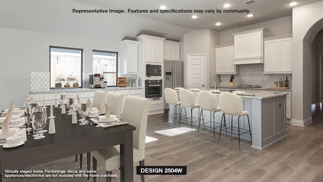 535 Oakview Bend Dr, Montgomery, TX 77316 - kitchen featuring stainless steel appliances, white cabinets, decorative backsplash, and light wood-style flooring