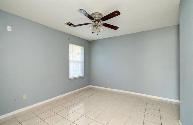 empty room featuring light tile patterned floors, visible vents, baseboards, and ceiling fan