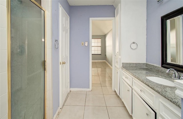 bathroom with vanity, tile patterned floors, baseboards, and a stall shower