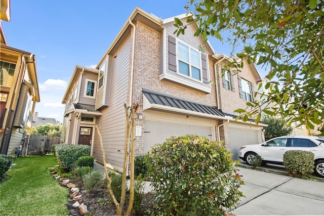 view of front of home featuring a garage, driveway, fence, a front yard, and brick siding