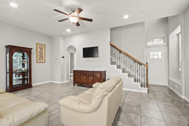 living room with arched walkways, a ceiling fan, marble finish floor, and recessed lighting