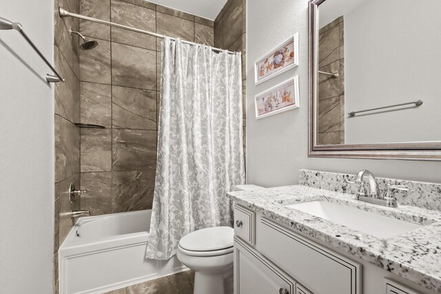 bathroom with wood finished floors, shower / bath combination with curtain, vanity, and toilet