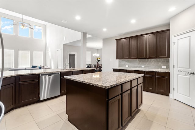 kitchen featuring dishwasher, a center island, light tile patterned floors, and a sink