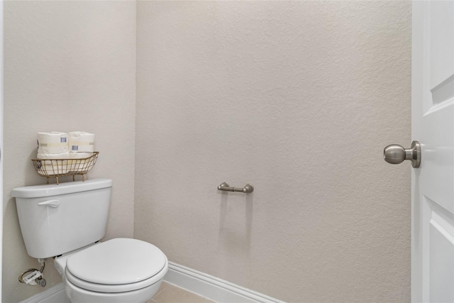 bathroom with tile patterned floors, baseboards, and toilet