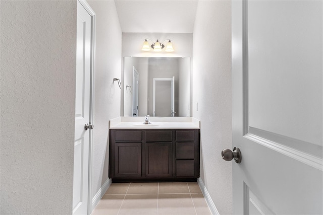 bathroom with tile patterned floors, vanity, and baseboards