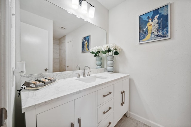 bathroom with visible vents, baseboards, wood finished floors, and vanity