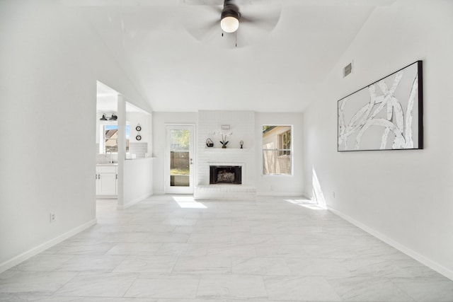 unfurnished living room with a ceiling fan, visible vents, baseboards, lofted ceiling, and a brick fireplace