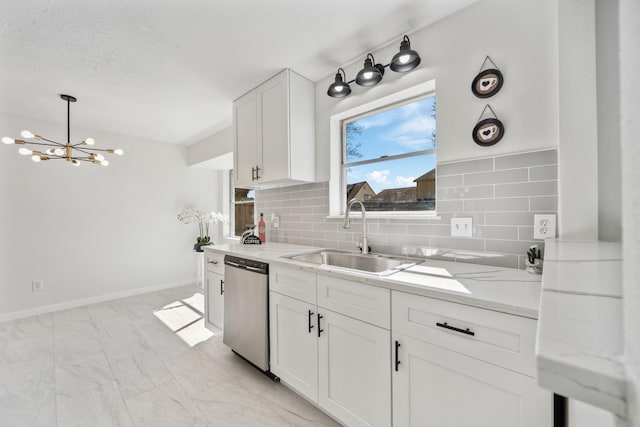 kitchen featuring dishwasher, white cabinets, an inviting chandelier, marble finish floor, and a sink