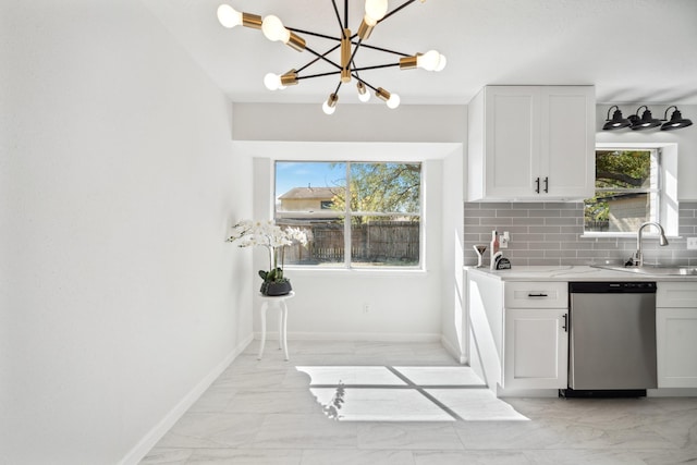 kitchen featuring a sink, decorative backsplash, dishwasher, marble finish floor, and a chandelier