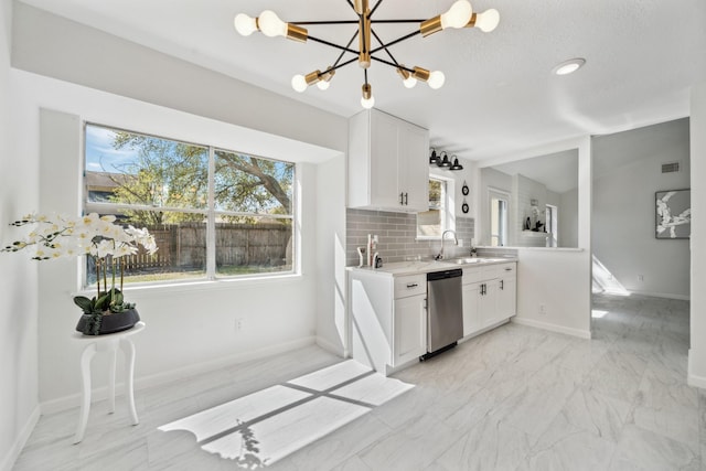 kitchen featuring decorative backsplash, plenty of natural light, dishwasher, and light countertops