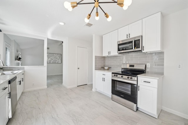 kitchen featuring visible vents, a sink, light countertops, appliances with stainless steel finishes, and backsplash