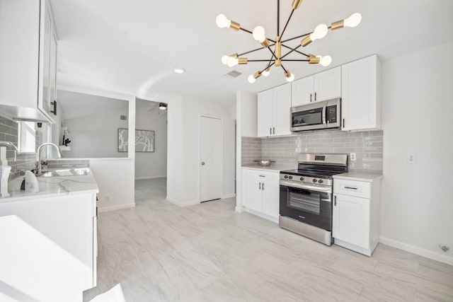 kitchen with visible vents, a chandelier, decorative backsplash, appliances with stainless steel finishes, and a sink