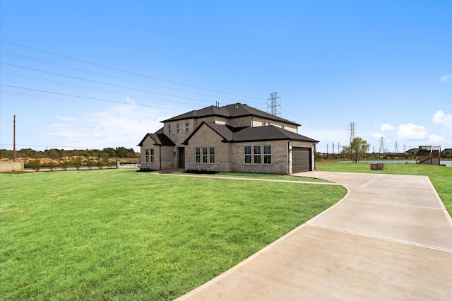 view of front of property featuring a front yard, a garage, and concrete driveway
