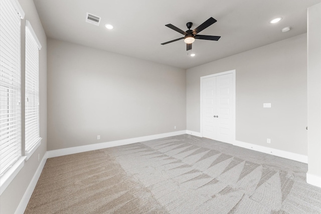 carpeted spare room with baseboards, visible vents, recessed lighting, and a ceiling fan