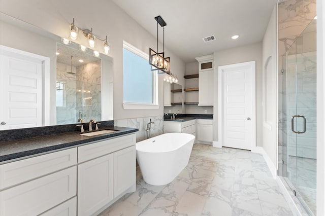bathroom featuring marble finish floor, vanity, a stall shower, and visible vents