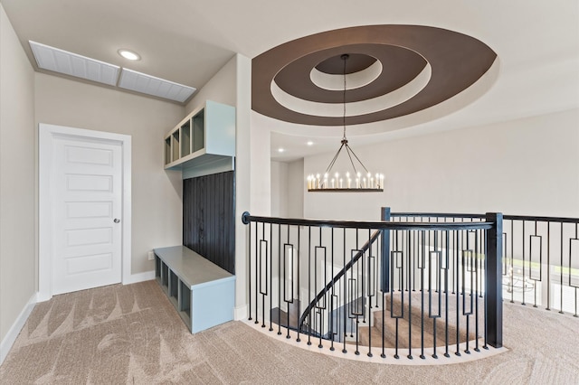 interior space featuring baseboards, carpet floors, a raised ceiling, and an inviting chandelier