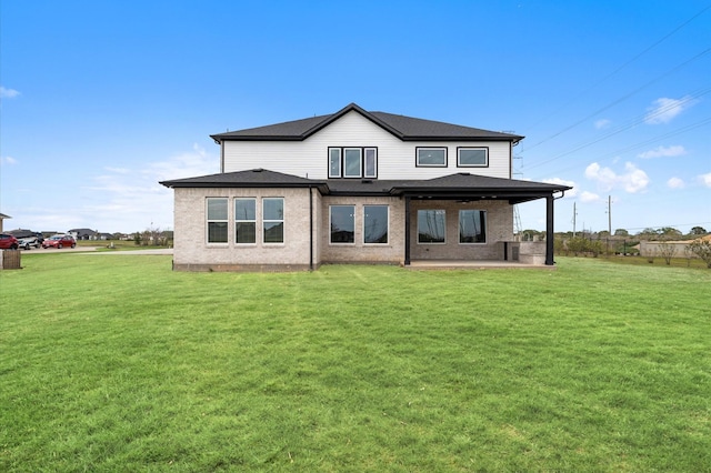 rear view of property with a lawn, a patio, and roof with shingles