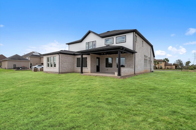 back of house featuring a lawn and a patio area