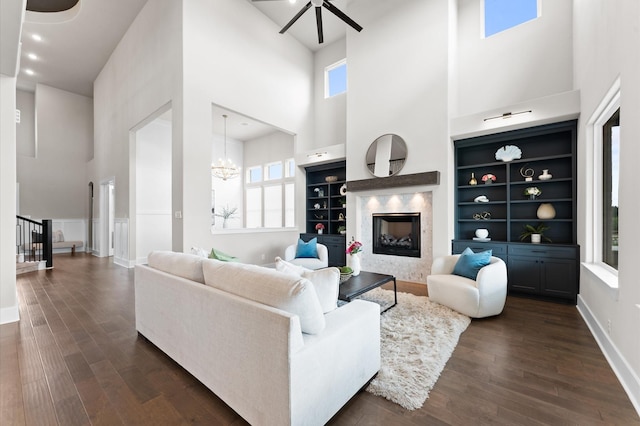 27003 Skiers Crossing Dr, Katy, TX 77493 - living area with a high ceiling, a premium fireplace, dark wood-style floors, a chandelier, and a ceiling fan