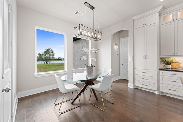 27003 Skiers Crossing Dr, Katy, TX 77493 - dining room with arched walkways, dark wood-style flooring, and a chandelier