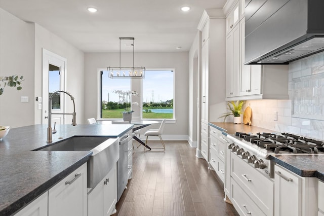 27003 Skiers Crossing Dr, Katy, TX 77493 - kitchen with appliances with stainless steel finishes, dark countertops, custom exhaust hood, recessed lighting, and backsplash