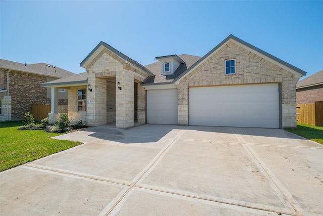 view of front of house featuring a garage, a front yard, fence, stone siding, and concrete driveway