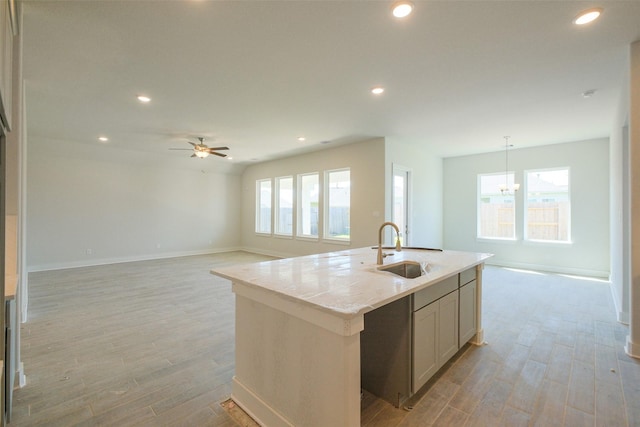 kitchen featuring light wood finished floors, a sink, and a wealth of natural light