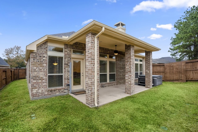 155 Forest Heights Ln, Montgomery, TX 77316 - rear view of property featuring brick siding, a fenced backyard, a lawn, and a ceiling fan