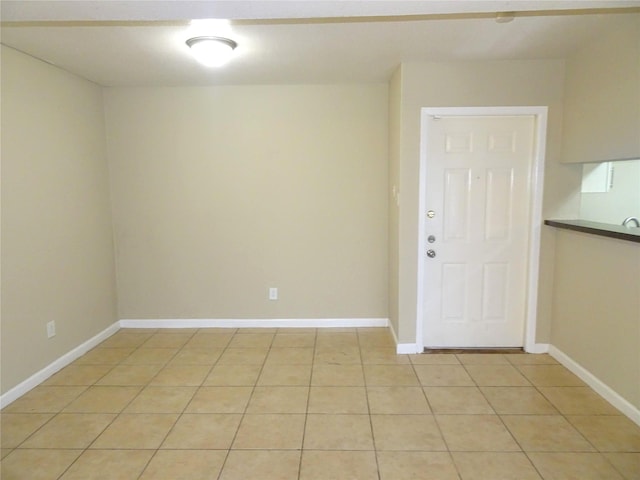 empty room featuring light tile patterned floors and baseboards