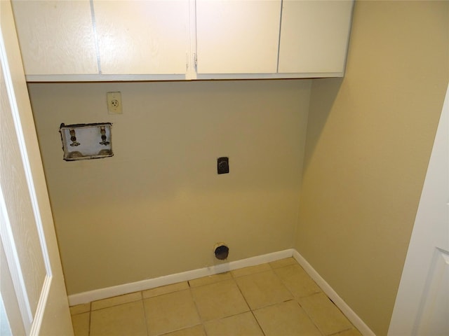 clothes washing area with baseboards, washer hookup, light tile patterned floors, cabinet space, and hookup for an electric dryer