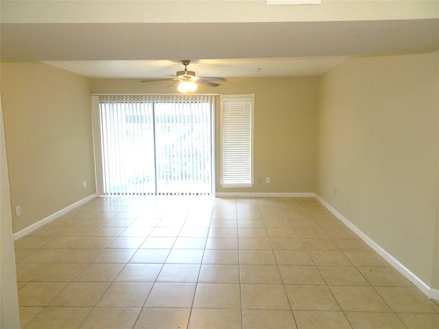 spare room with light tile patterned floors, a ceiling fan, and baseboards