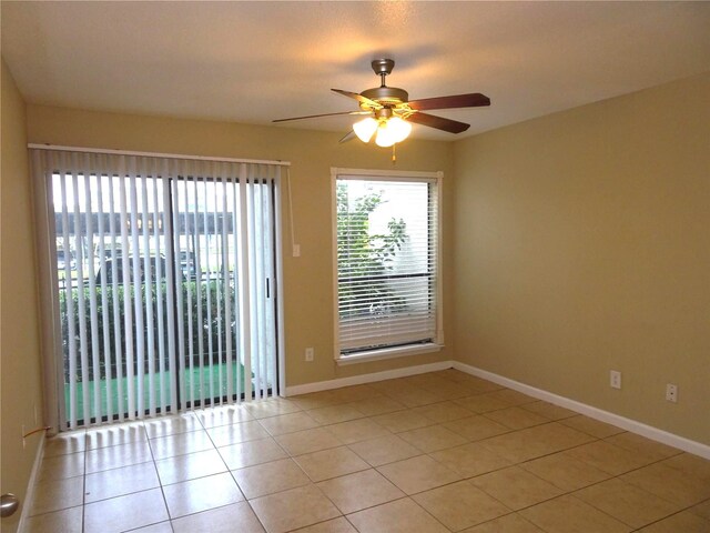unfurnished room with light tile patterned floors, baseboards, and a ceiling fan
