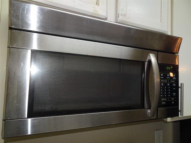 room details featuring stainless steel microwave and white cabinetry