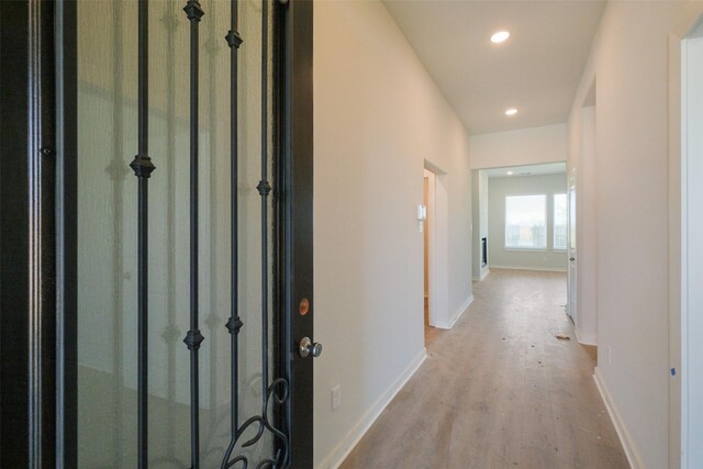 hallway with wood finished floors, baseboards, and recessed lighting