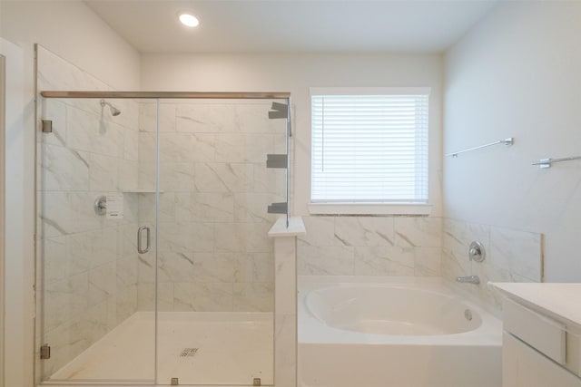 bathroom featuring a shower stall, a bath, and vanity