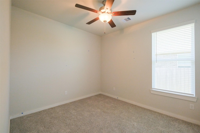 carpeted empty room featuring visible vents, baseboards, and ceiling fan