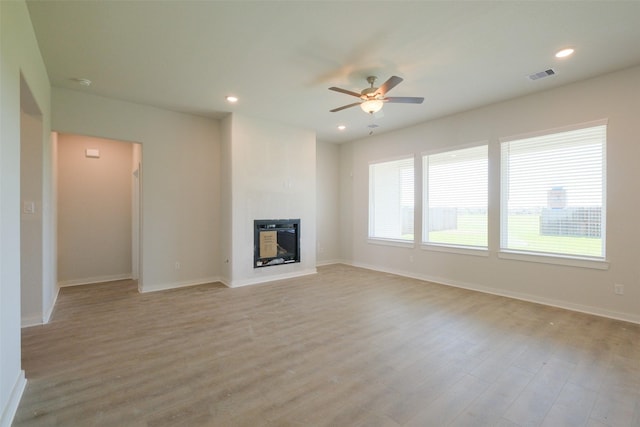 unfurnished living room featuring visible vents, light wood-type flooring, a ceiling fan, recessed lighting, and a glass covered fireplace