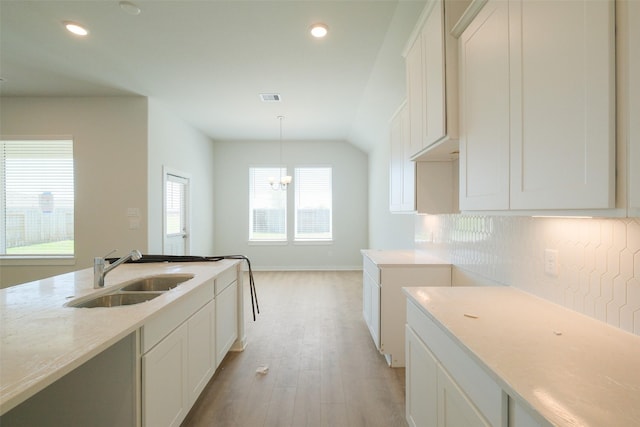 kitchen featuring recessed lighting, light wood-style floors, white cabinetry, and a sink