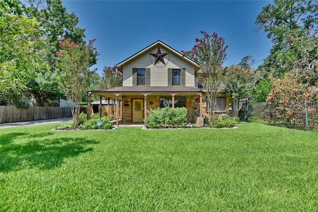 view of front facade featuring covered porch, a front yard, and fence