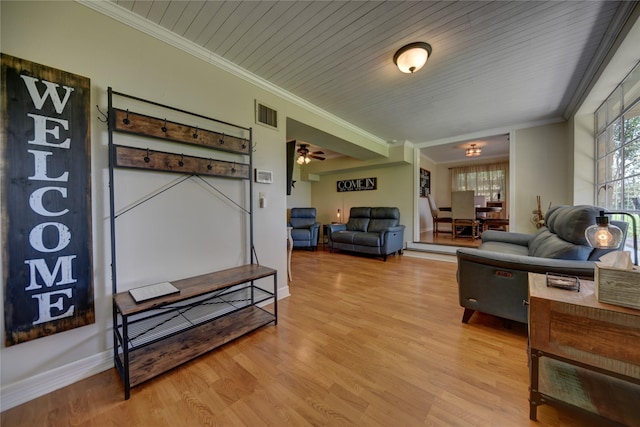 living area featuring visible vents, baseboards, light wood-type flooring, ornamental molding, and wooden ceiling