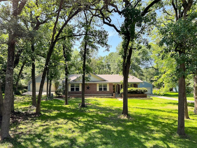518 Lcr 902, Jewett, TX 75846 - view of front of house featuring an attached garage, aphalt driveway, a front lawn, and brick siding