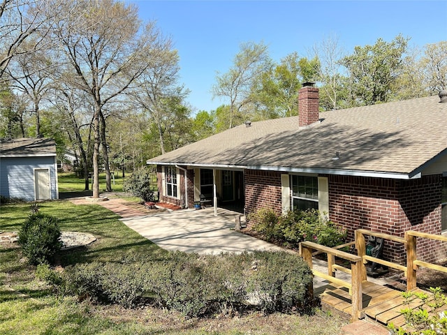 518 Lcr 902, Jewett, TX 75846 - rear view of house featuring brick siding, roof with shingles, a patio, and an outdoor structure