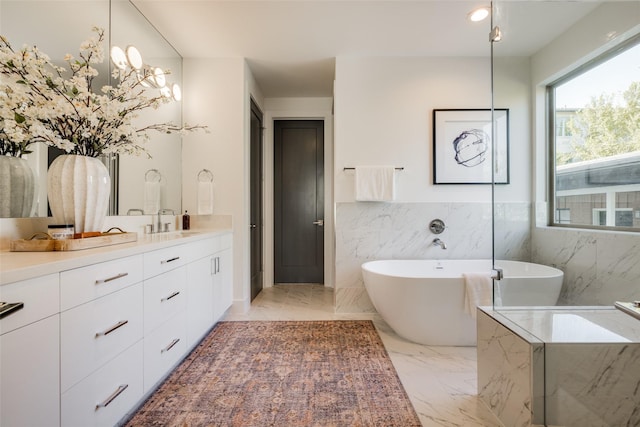 1609 Park St, Houston, TX 77019 - bathroom featuring vanity, a freestanding bath, marble finish flooring, tile walls, and a wainscoted wall