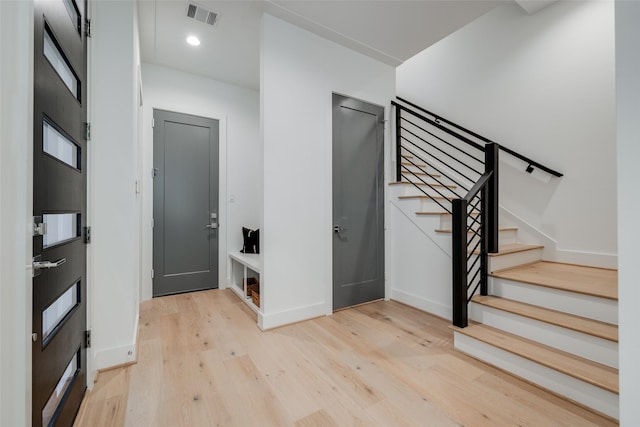 1609 Park St, Houston, TX 77019 - entryway featuring light wood finished floors, stairs, and baseboards