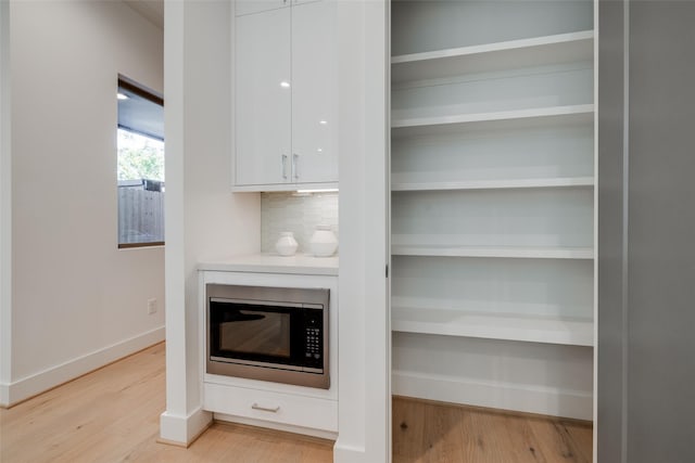 1609 Park St, Houston, TX 77019 - detailed view of built in microwave, wood finished floors, baseboards, and tasteful backsplash