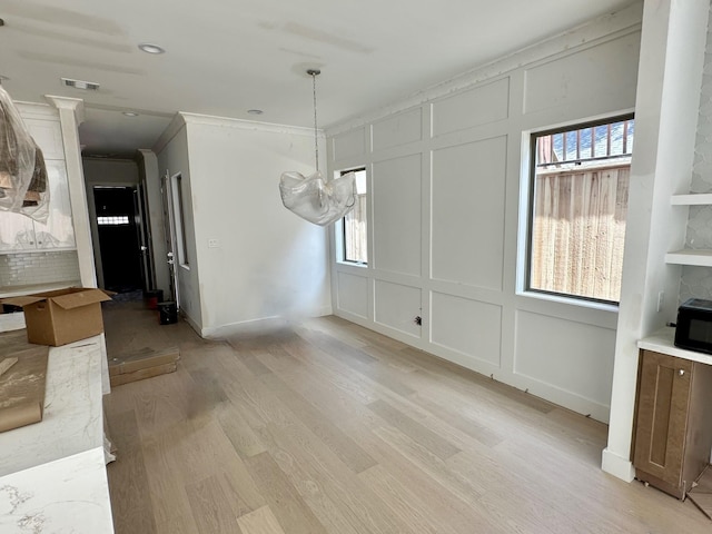 1609 Park St, Houston, TX 77019 - unfurnished dining area featuring a decorative wall, light wood-style floors, a chandelier, and ornamental molding