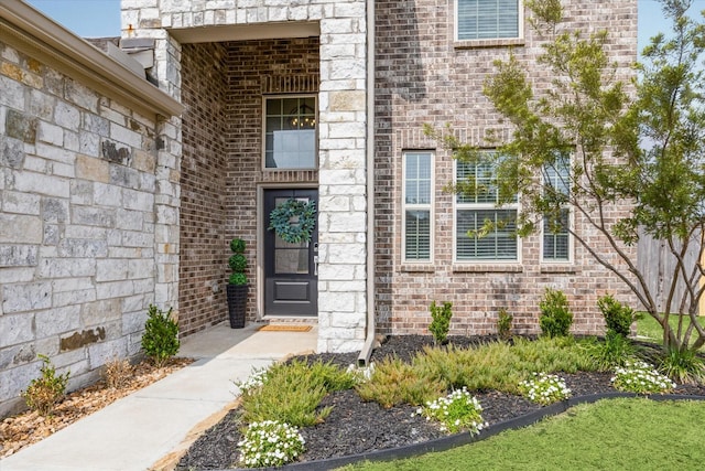 view of exterior entry featuring brick siding