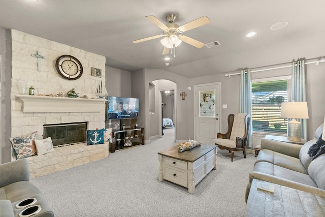 living room featuring arched walkways, visible vents, light colored carpet, and a ceiling fan