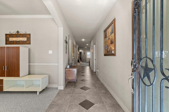 tiled foyer entrance with baseboards and arched walkways